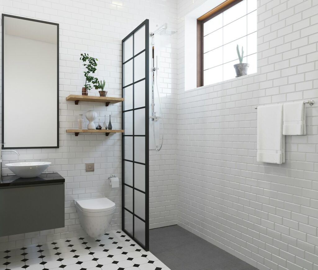 Modern bathroom remodel featuring distinct wet and dry zones with glass partitions and sleek fixtures by Estate Contractor.